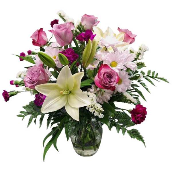 Mixed bouquet of pink roses, lilies, and daisies in a glass vase