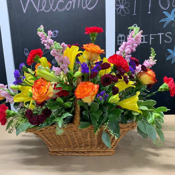 Colorful mixed flower arrangement in a wicker basket