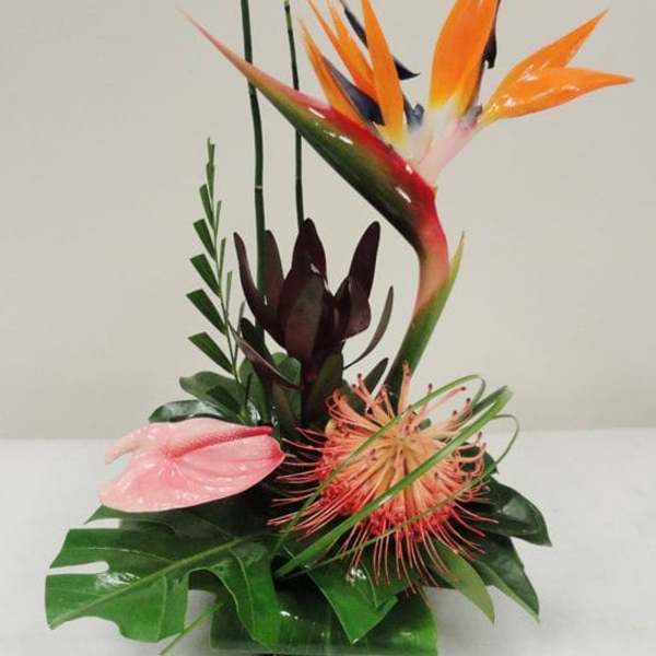 Tropical floral arrangement with orange bird of paradise and pink anthurium