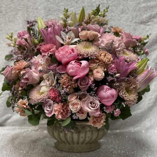 Pink mixed flower arrangement in a decorative urn vase