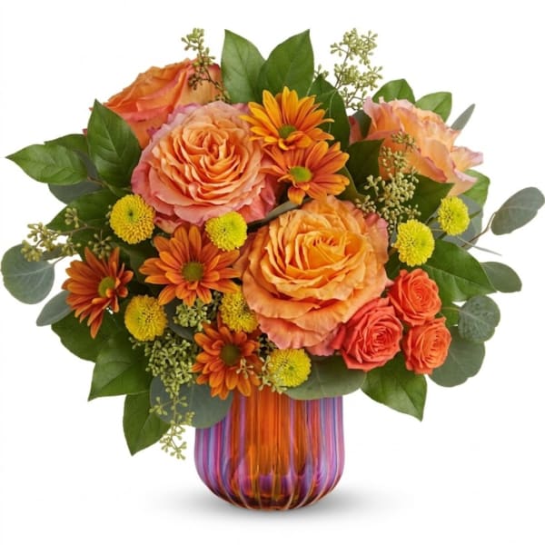 Orange roses and daisies arranged in a striped glass vase