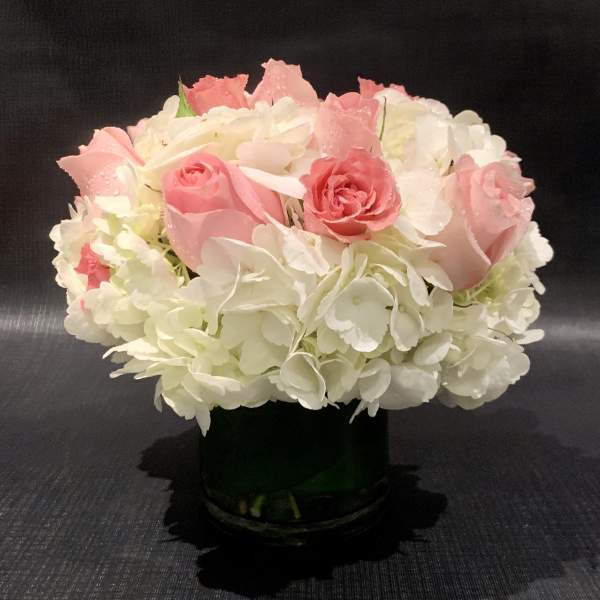 Pink roses and white hydrangeas in a dark vase