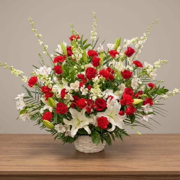 Red roses and white lilies in a white basket vase