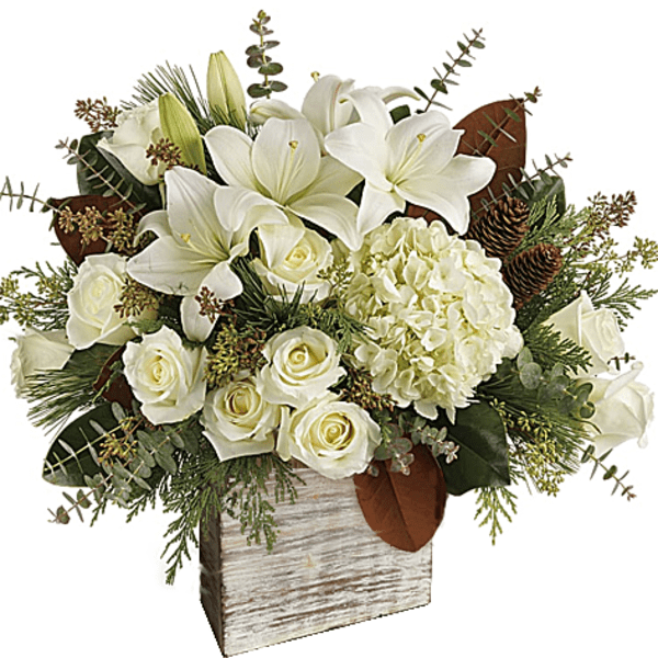 White lilies and roses in a rustic wooden vase with greenery