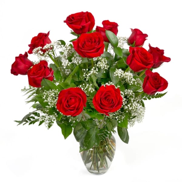 Bouquet of red roses with baby's breath in a clear glass vase