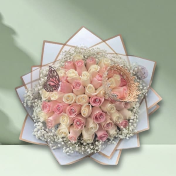 Bouquet of pink and cream roses with baby’s breath and decorative butterfly accents