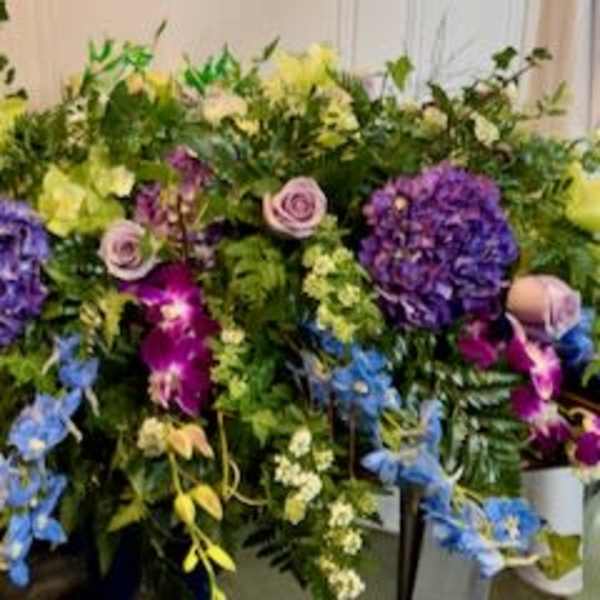 Large mixed floral spray with purple, yellow, blue, and pink blooms