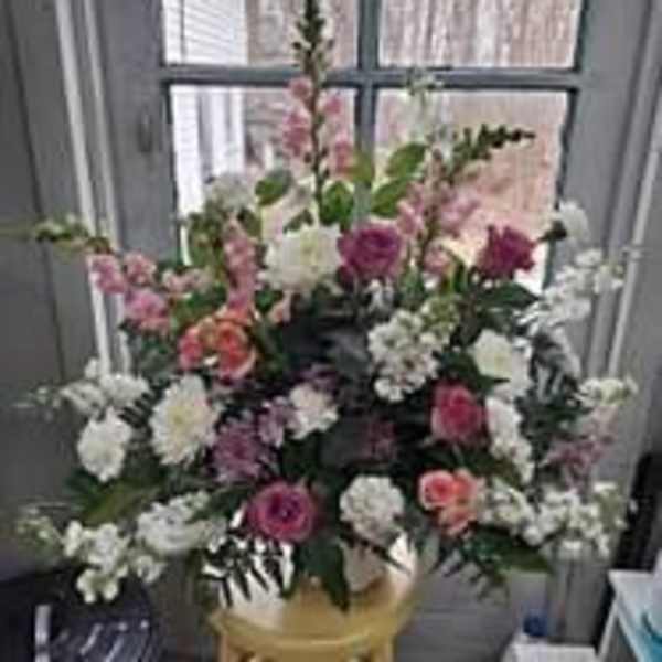 Mixed pink and white floral arrangement in a gold vase