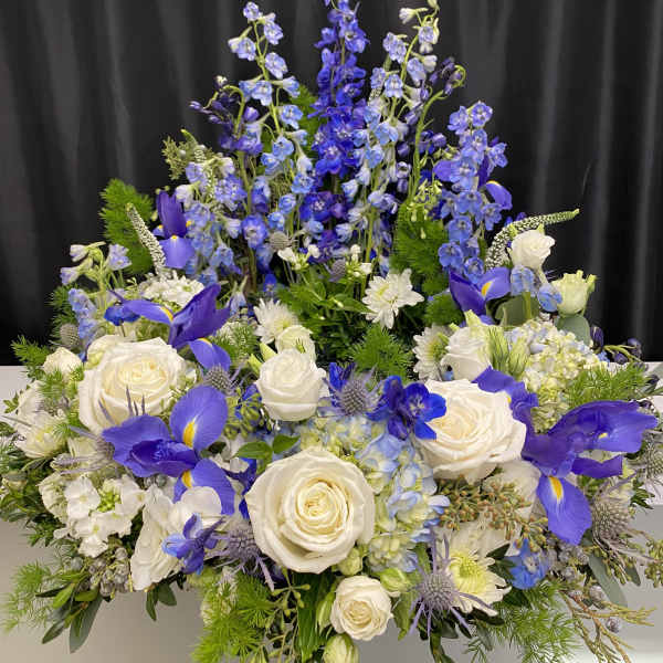Blue and white floral arrangement with roses and iris flowers