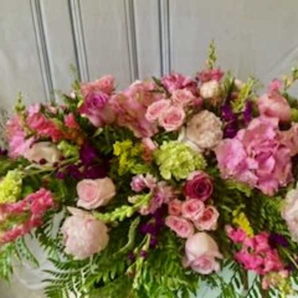 Large pink and white floral arrangement with roses and mixed blooms