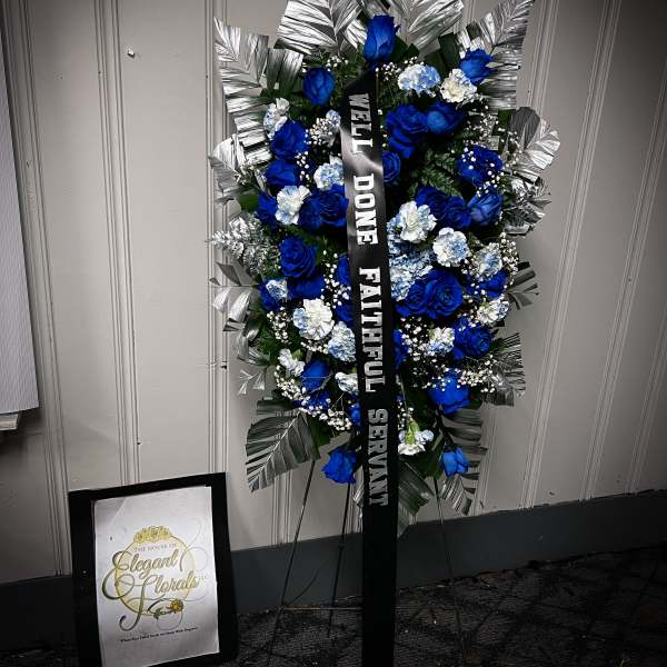 Blue and white funeral standing spray with a black ribbon