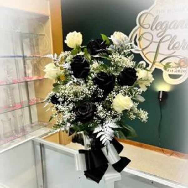 Black and white floral arrangement in a vase with ribbon