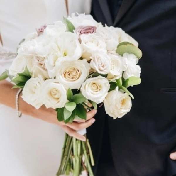 White rose bouquet with pale pink accents and greenery