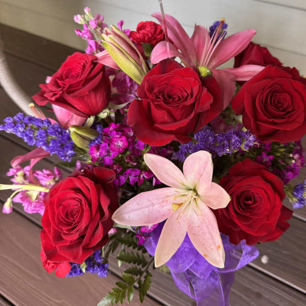 Bouquet of red roses and pink lilies with purple filler flowers