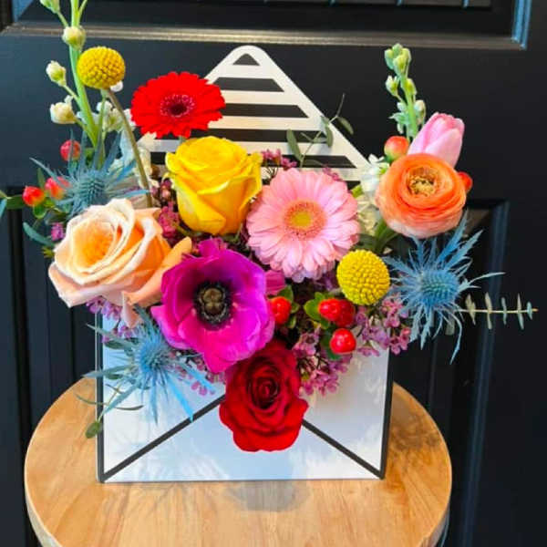 Colorful mixed flower arrangement in a white box with roses and gerbera daisies