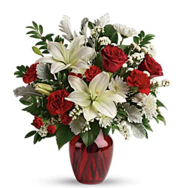 Red roses and white lilies in a red glass vase