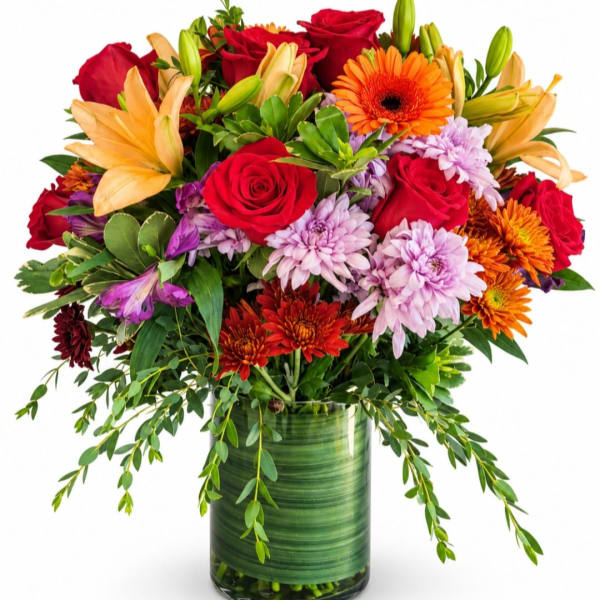 Mixed bouquet of roses, lilies, and chrysanthemums in a green glass vase