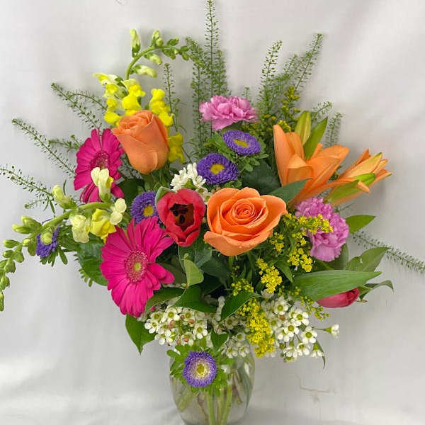Mixed bouquet of colorful flowers in a clear glass vase