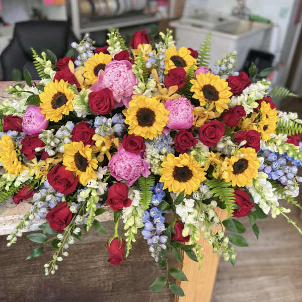 Large mixed bouquet with sunflowers, red roses, and pink blooms
