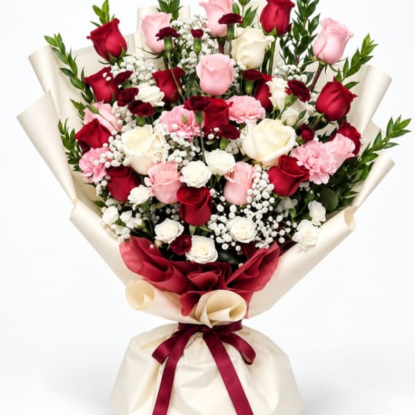 Bouquet of red, pink, and white roses with carnations wrapped in cream paper