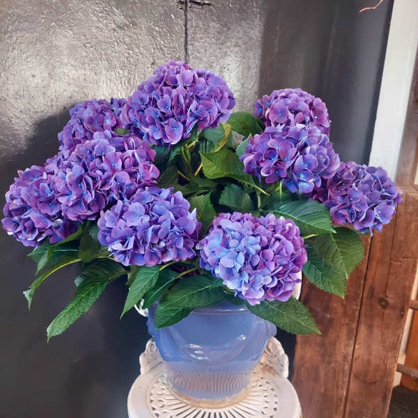 Purple hydrangea bouquet in a blue vase