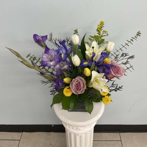Purple and white mixed bouquet in a glass vase