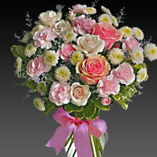 Pink and white rose bouquet in a striped glass vase with a pink ribbon