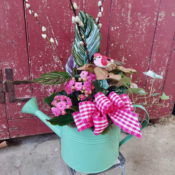 Pink flowers in a mint watering can with a gingham bow and bird decoration