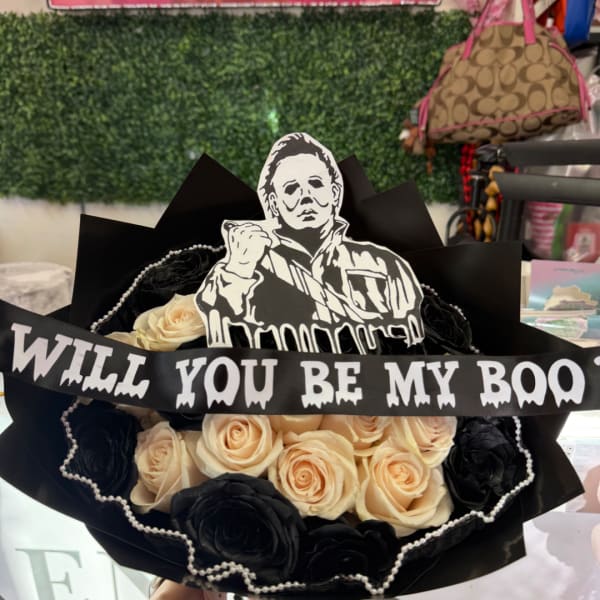 Black and cream rose bouquet with a Halloween character topper and banner