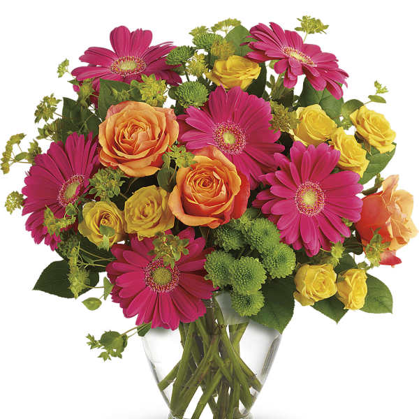 Bouquet of pink gerbera daisies and yellow-orange roses in a clear glass vase
