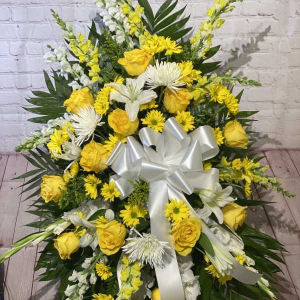 Large yellow and white floral spray with a white ribbon bow