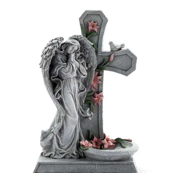 Stone angel statue beside a cross with pink flowers