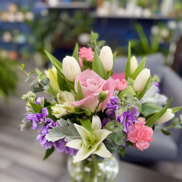 Pink roses and white tulips in a clear glass vase