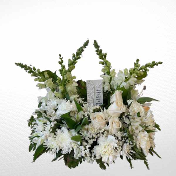 White floral sympathy arrangement with roses and daisies around a memorial card