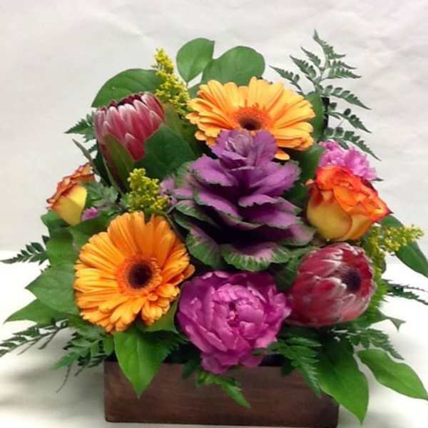 Colorful bouquet with gerbera daisies and roses in a wooden box