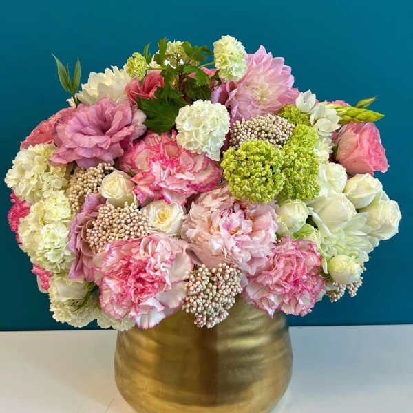 Pink and white floral arrangement in a gold vase