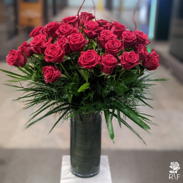 Bouquet of red roses in a tall glass vase