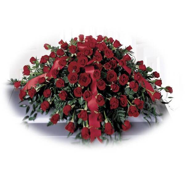 Large arrangement of red roses with ribbon on a white casket