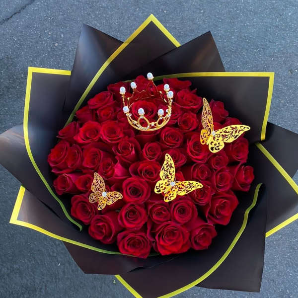 Bouquet of red roses with gold butterfly decorations and black wrapping
