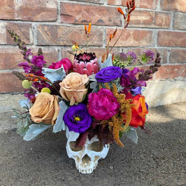 Colorful bouquet arranged in a white skull container