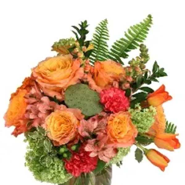 Orange roses and tulips in a glass vase