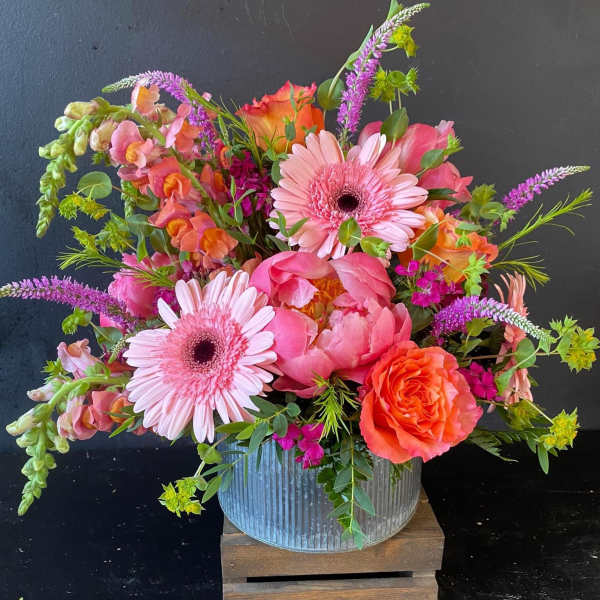 Bright pink and orange mixed bouquet in a ribbed metal container
