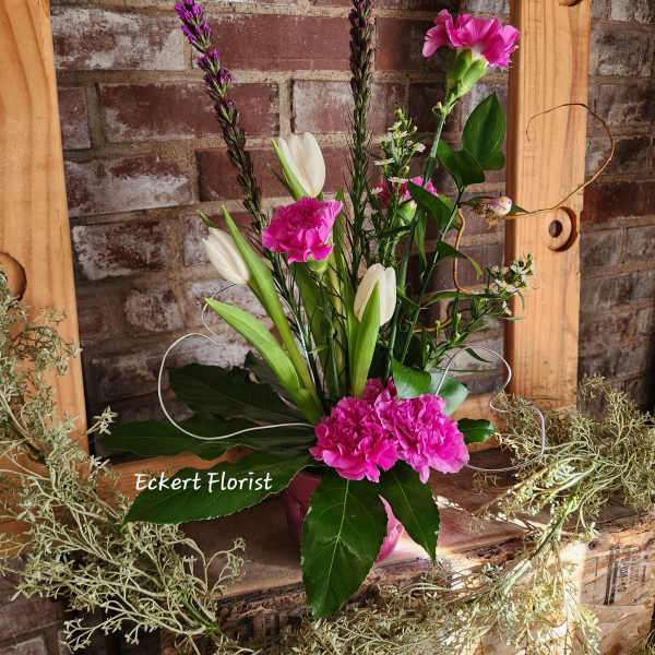 Pink and white floral arrangement with tulips and carnations in a vase