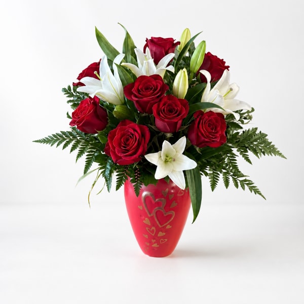 Red roses and white lilies in a red heart-decorated vase