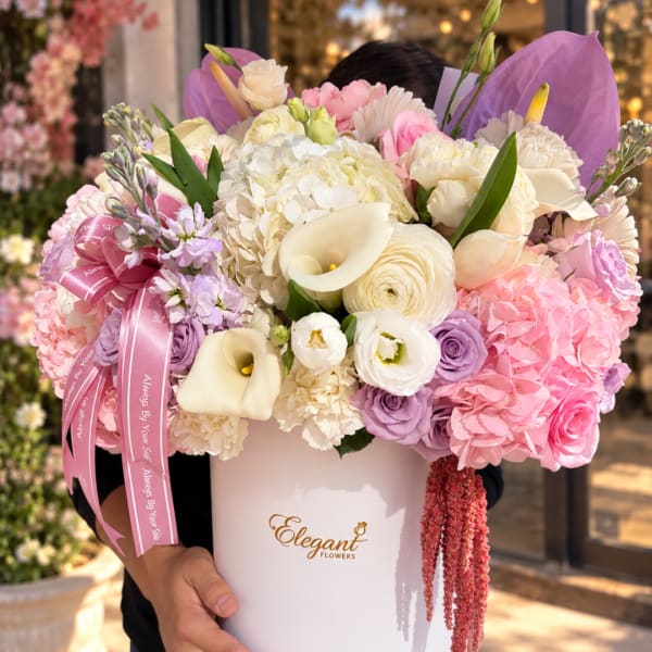 Large pastel bouquet in a white hatbox with pink ribbon