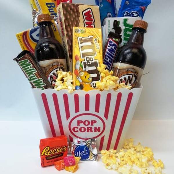 Popcorn bucket filled with candy bars and two soda bottles
