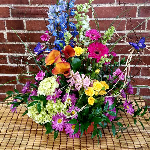 Colorful mixed flower arrangement with calla lilies, roses, and daisies