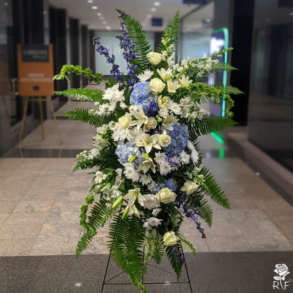 Tall standing floral spray with white, blue, and purple flowers