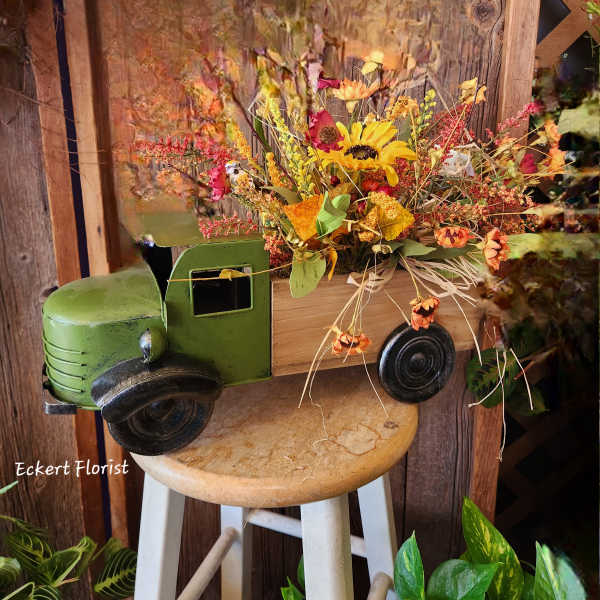 Fall floral arrangement in a decorative truck container
