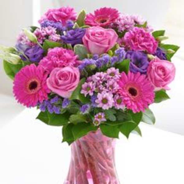 Pink and purple mixed bouquet in a pink glass vase